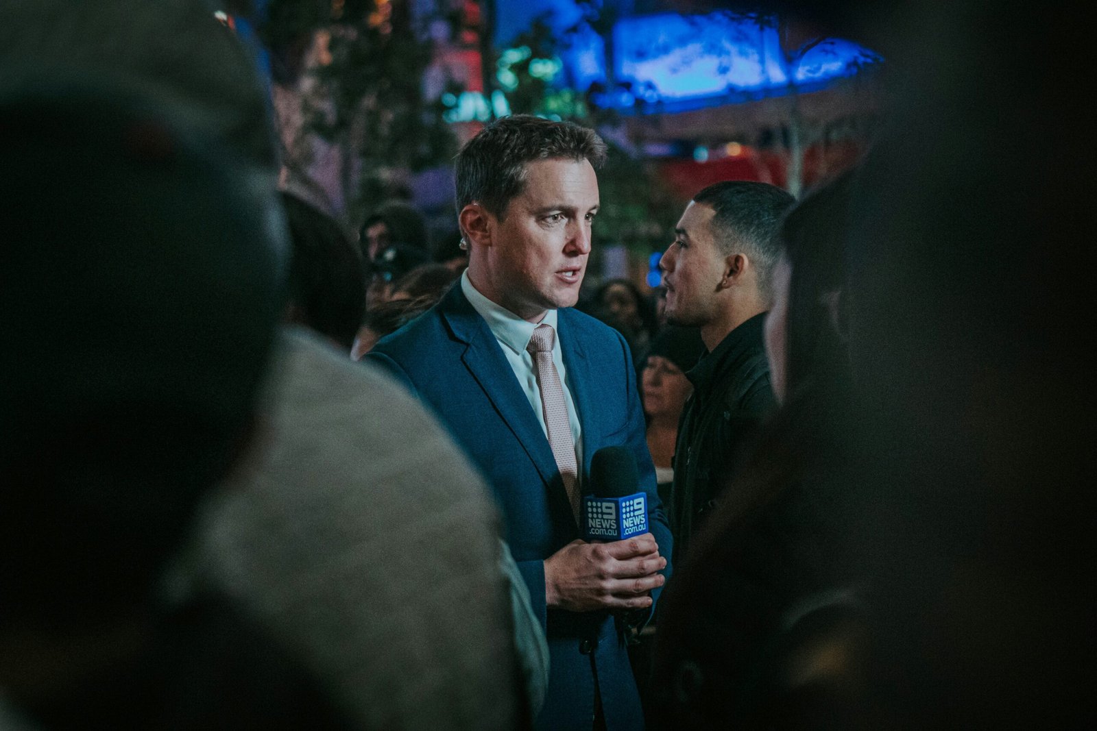 man in black suit standing in front of man in black suit